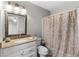 Neutral bathroom featuring white vanity, decorative mirror, and shower with colorful curtain at 7952 Grand Pines Blvd, Lakeland, FL 33810