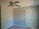 This bedroom has neutral paint and tile flooring and includes a ceiling fan with lighting at 7952 Grand Pines Blvd, Lakeland, FL 33810