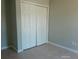 Bedroom featuring a large closet with bi-fold doors, neutral walls, and tile flooring, perfect for storage and style at 7952 Grand Pines Blvd, Lakeland, FL 33810