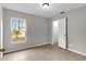 Bright bedroom featuring neutral walls, tiled floors, a window view, and an open closet door at 7952 Grand Pines Blvd, Lakeland, FL 33810