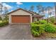 Charming single-story home featuring a well-maintained lawn, trimmed shrubs, and a two-car attached garage at 7952 Grand Pines Blvd, Lakeland, FL 33810