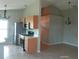 Open-concept kitchen featuring stainless steel appliances, light wood cabinets, tile floors, and an open layout at 7952 Grand Pines Blvd, Lakeland, FL 33810