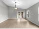 Spacious living room with tile flooring, modern lighting, and glass doors leading to outdoor spaces at 7952 Grand Pines Blvd, Lakeland, FL 33810