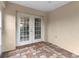 Covered patio with unique tile flooring and french doors leading inside the home at 7952 Grand Pines Blvd, Lakeland, FL 33810