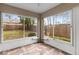 Enclosed sunroom with large windows offering backyard views and unique tile flooring at 7952 Grand Pines Blvd, Lakeland, FL 33810