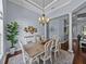 Bright dining room with a decorative chandelier and space for seating six, complemented by hardwood floors at 800 Osprey Landing Dr, Lakeland, FL 33813