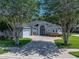 Charming single-story home with a well-manicured lawn, mature trees, and a welcoming front entrance at 800 Osprey Landing Dr, Lakeland, FL 33813