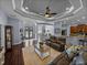 Inviting living room featuring hardwood floors, tray ceiling, and an open layout leading to the kitchen at 800 Osprey Landing Dr, Lakeland, FL 33813