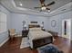 Inviting main bedroom with tray ceiling, ceiling fan, hardwood floors, and decorative accents at 800 Osprey Landing Dr, Lakeland, FL 33813