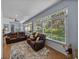 Bright sun room with leather couches and an inviting view of the backyard and pool at 800 Osprey Landing Dr, Lakeland, FL 33813