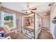 Cozy bedroom with a four-poster bed, charming decor, and a bright window view at 818 Fairlane Dr, Lakeland, FL 33809