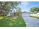 Well-maintained home with a green lawn and a paved driveway leading to an attached garage at 818 Fairlane Dr, Lakeland, FL 33809