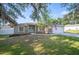 Inviting single-story home with a neatly landscaped lawn, white trim and a light blue front door at 818 Fairlane Dr, Lakeland, FL 33809