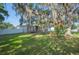 Charming home with a lush green lawn, mature trees, and a rustic swing at 818 Fairlane Dr, Lakeland, FL 33809