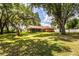 Beautiful backyard featuring a lush lawn, mature trees, and a screened-in patio at 909 Lake Deeson Pt, Lakeland, FL 33805