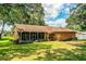 Expansive backyard featuring lush green grass, mature trees, and a screened-in patio at 909 Lake Deeson Pt, Lakeland, FL 33805