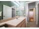 Bathroom featuring a vanity with a single sink, a mirrored wall, and a view to the hallway at 909 Lake Deeson Pt, Lakeland, FL 33805