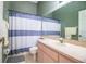Bathroom featuring a vanity with a single sink and a shower/tub combination with a striped curtain at 909 Lake Deeson Pt, Lakeland, FL 33805