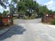 Brick entrance to a private road with mature landscaping and a central fountain at 909 Lake Deeson Pt, Lakeland, FL 33805
