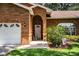Charming brick home's front entrance featuring an arched doorway and well-kept landscaping at 909 Lake Deeson Pt, Lakeland, FL 33805