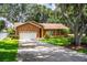 Brick home with lush lawn, long driveway, and mature trees providing ample shade at 909 Lake Deeson Pt, Lakeland, FL 33805