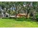 Brick home with manicured lawn, mature trees, and a neatly fenced yard in a quiet neighborhood at 909 Lake Deeson Pt, Lakeland, FL 33805