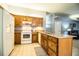 Bright kitchen with wood cabinets, island with granite countertops, and white appliances at 909 Lake Deeson Pt, Lakeland, FL 33805