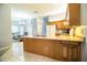 Kitchen featuring an island with granite countertops and wood cabinetry, tile floors and stainless sink at 909 Lake Deeson Pt, Lakeland, FL 33805