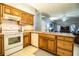 Bright kitchen with wood cabinets, granite countertops, tile floors, and white appliances at 909 Lake Deeson Pt, Lakeland, FL 33805