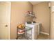 Functional laundry room with white washer and dryer, storage cart, and shelving at 909 Lake Deeson Pt, Lakeland, FL 33805