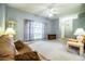 Spacious living room with neutral carpet, large window, ceiling fan, and comfortable seating at 909 Lake Deeson Pt, Lakeland, FL 33805
