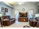 Living room featuring neutral walls, a large tv, a ceiling fan and leather furniture at 909 Lake Deeson Pt, Lakeland, FL 33805