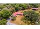 Aerial view of a property featuring multiple buildings, a red metal roof, and surrounding foliage at 3822 Charter Rd, Lakeland, FL 33810