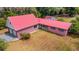 Aerial view of property featuring red metal roof, brick facade, two-car garage, and large backyard at 3822 Charter Rd, Lakeland, FL 33810