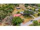 Aerial view of property featuring multiple buildings, a red metal roof, swimming pool, and lush trees at 3822 Charter Rd, Lakeland, FL 33810