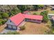 Aerial view of a well-manicured lawn with a red roof, brick facade, and two-car garage at 3822 Charter Rd, Lakeland, FL 33810