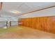 Spacious bonus room featuring wood paneling, wood-look floors, and access to upper level at 3822 Charter Rd, Lakeland, FL 33810
