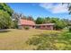 Well-manicured lawn with home featuring a red roof, brick facade, and a two-car garage at 3822 Charter Rd, Lakeland, FL 33810