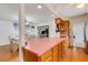 Open kitchen with pink countertops, wooden cabinets, and view of the dining room at 3822 Charter Rd, Lakeland, FL 33810