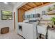 Functional laundry room with modern washer/dryer, sink, storage shelves and bright window at 3822 Charter Rd, Lakeland, FL 33810