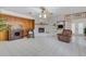 Living room with tile floors, a painted brick fireplace, wood paneled wall, and comfortable seating at 3822 Charter Rd, Lakeland, FL 33810