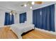 Bright main bedroom with hardwood floors and large windows covered by navy-blue curtains at 3822 Charter Rd, Lakeland, FL 33810