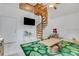 Spacious playroom featuring a spiral staircase, TV, and a green leaf rug at 3822 Charter Rd, Lakeland, FL 33810