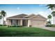 Charming single-story home featuring a two-car garage, well-maintained lawn, and tropical landscaping at 1009 Aruba Ave, Mulberry, FL 33860