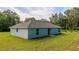 An expansive backyard featuring a lush lawn and sliding glass doors, offering a seamless indoor/outdoor flow at 10470 Sw 139Th Ct, Dunnellon, FL 34432
