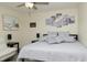 Comfortable bedroom featuring ceiling fan, neutral walls, and gray bedding in a naturally lit space at 10470 Sw 139Th Ct, Dunnellon, FL 34432