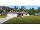 Charming single-story home with a two-car garage, landscaped yard, and a vibrant red front door at 10470 Sw 139Th Ct, Dunnellon, FL 34432