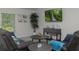 Comfortable living room with two leather couches, round wooden tables, and large screen TV at 10470 Sw 139Th Ct, Dunnellon, FL 34432