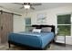 Bright main bedroom featuring wood-look floors, barn door accent, ceiling fan, and view to the outdoors at 10470 Sw 139Th Ct, Dunnellon, FL 34432