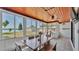 Bright sunroom with wood ceiling, tile floor, dining table, and lake view at 118 Lake Sears Dr, Winter Haven, FL 33880